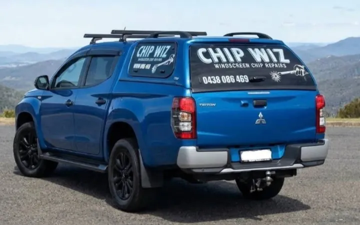 Rear view of the blue Chip Wiz Mitsubishi Triton ute, its canopy window signwritten CHIP WIZ, Windscreen Chip Repairs, 0438 086 469